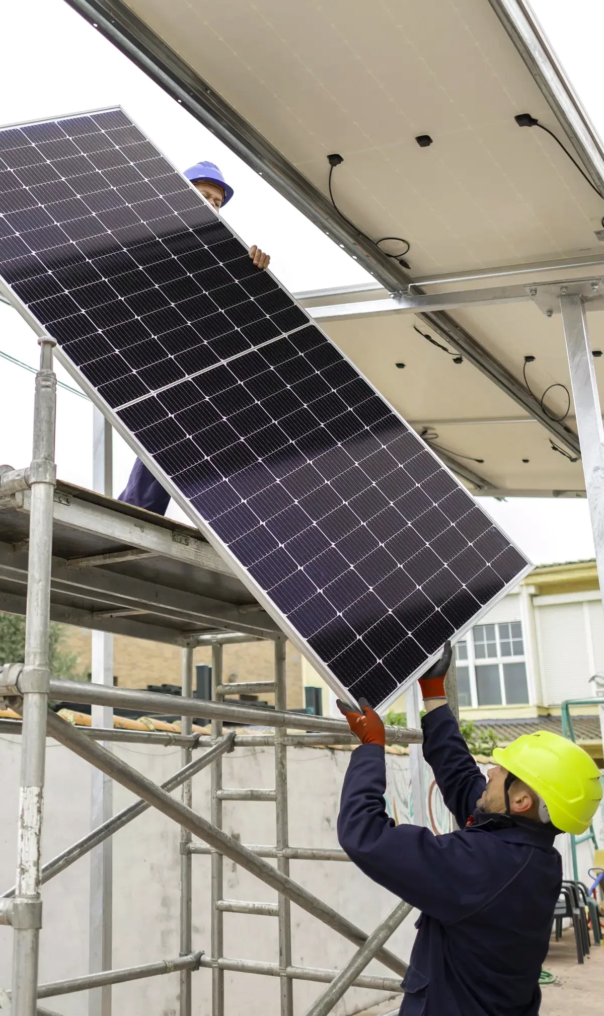 Operarios montando paneles solares con andamio en un edificio de Santa Coloma de Gramenet